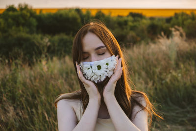 Close-up of young woman wearing mask standing outdoors