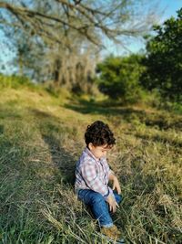 Full length of baby boy sitting on grass at park