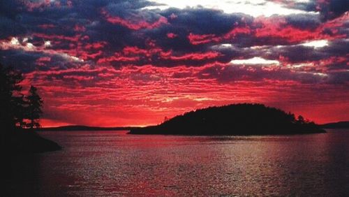 Scenic view of sea against cloudy sky at sunset