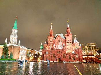 Illuminated buildings in city against sky at night