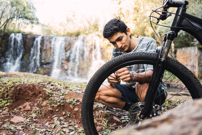 Male cyclist fixing mechanism of bicycle against hiker setting in forest