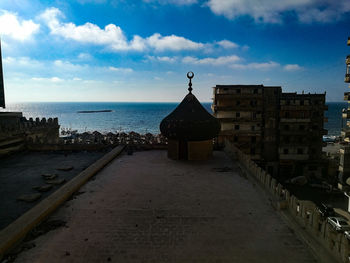 Building by sea against sky in city