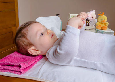 Portrait of baby boy lying on bed at home