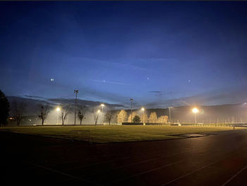 Illuminated street lights on soccer field at night