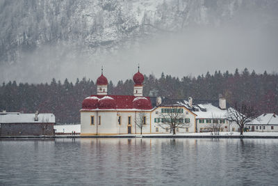 Buildings by river during winter