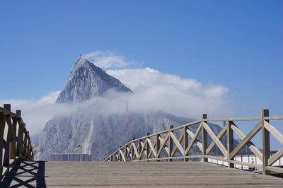 Bridge over sea against blue sky