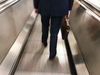 Blurred motion of people walking on escalator