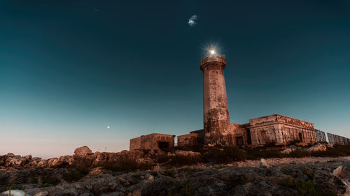 Low angle view of illuminated tower against sky at night