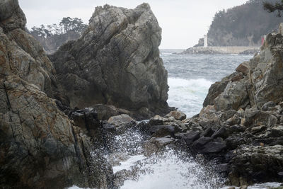 Rock formation in sea against sky