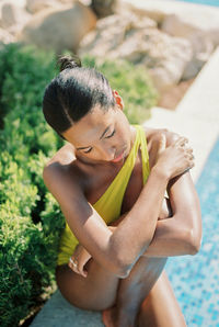 Side view of young woman sitting on field