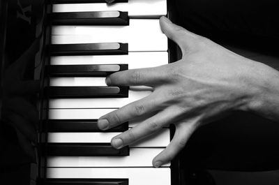 Close-up of hand playing piano