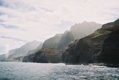 Scenic view of sea and mountains against sky