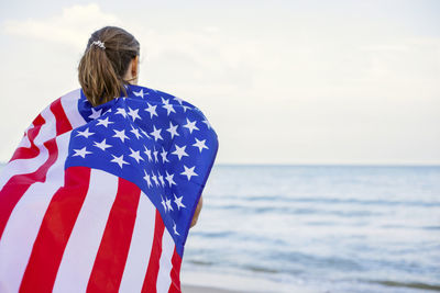 Rear view of woman looking at sea against sky