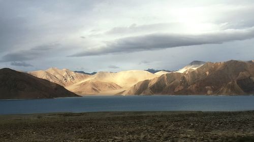 Scenic view of mountains against cloudy sky