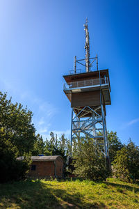 Low angle view of old tower on field against sky