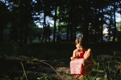 Full length of girl sitting on field