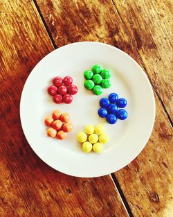 High angle view of multi colored candies in plate on table