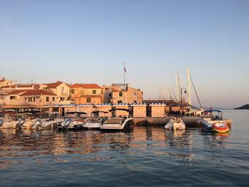 Boats in harbor against buildings in city