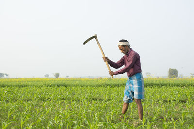 Full length of farmer working at farm land