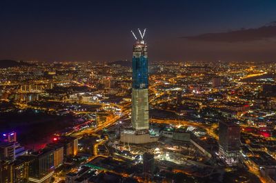 Illuminated cityscape against sky at night