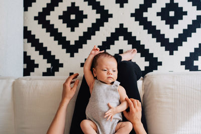 Full length of baby girl sitting on sofa at home