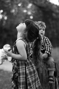 Side view of girl with eyes closed standing at park