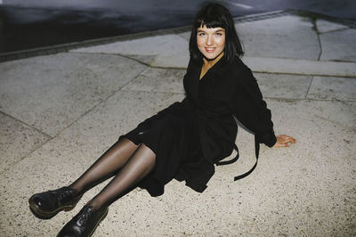 Happy woman sitting on a walkway