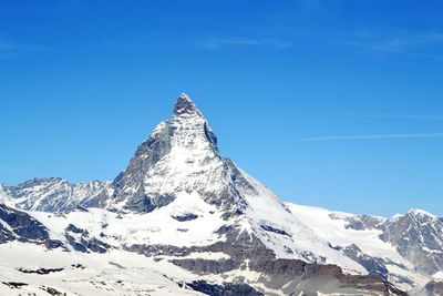 Scenic view of snowcapped mountains against clear blue sky