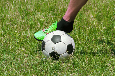 Low section of man playing soccer on field