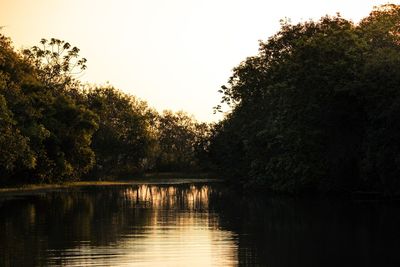 Scenic view of lake against clear sky at sunset