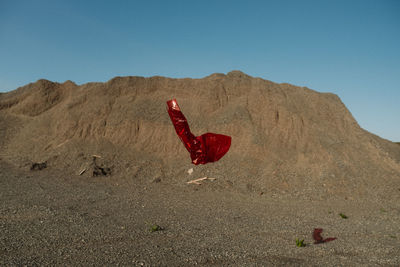 Red rock in desert against clear sky