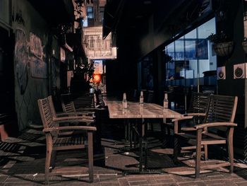 Empty chairs and tables in cafe at night