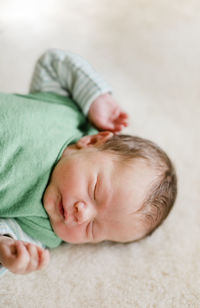 Close-up of baby boy sleeping on bed at home