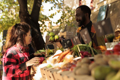 Side view of young man holding vegetables