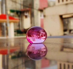 Close-up of crystal ball on glass against building