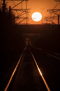 Railroad tracks against sky during sunset