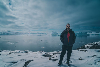 Rear view of man standing on snow covered landscape