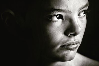 Close-up of thoughtful teenage boy in darkroom