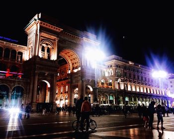 People on illuminated street at night