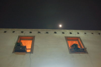 Low angle view of illuminated building against sky at night