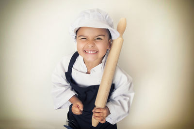 Portrait of smiling girl standing against white background