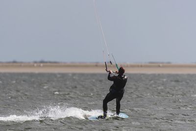 Man with umbrella on beach against sky