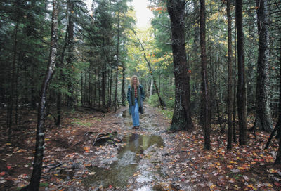 Man standing by trees in forest