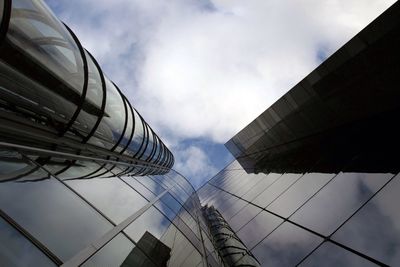 Low angle view of modern building against cloudy sky