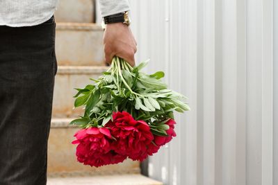 Midsection of man holding rose bouquet