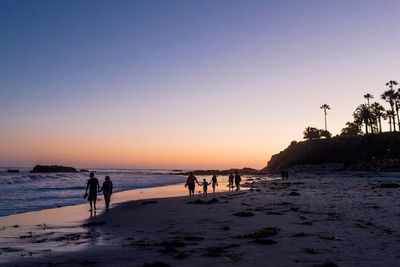 People at beach during sunset