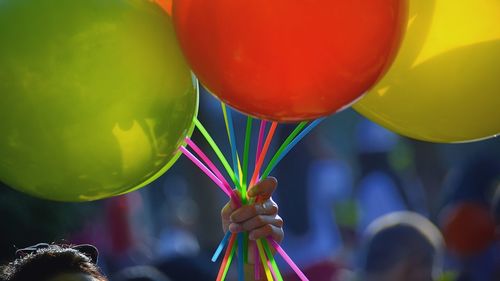 Cropped image of woman holding balloons