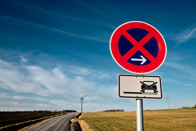 Road sign against sky