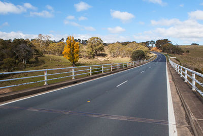 Road amidst trees against sky