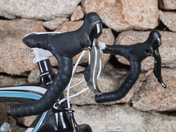 Close-up of bicycle against stone wall